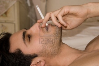 変換 ～ 2828535-man-lying-on-the-bed-lighting-a-cigarette